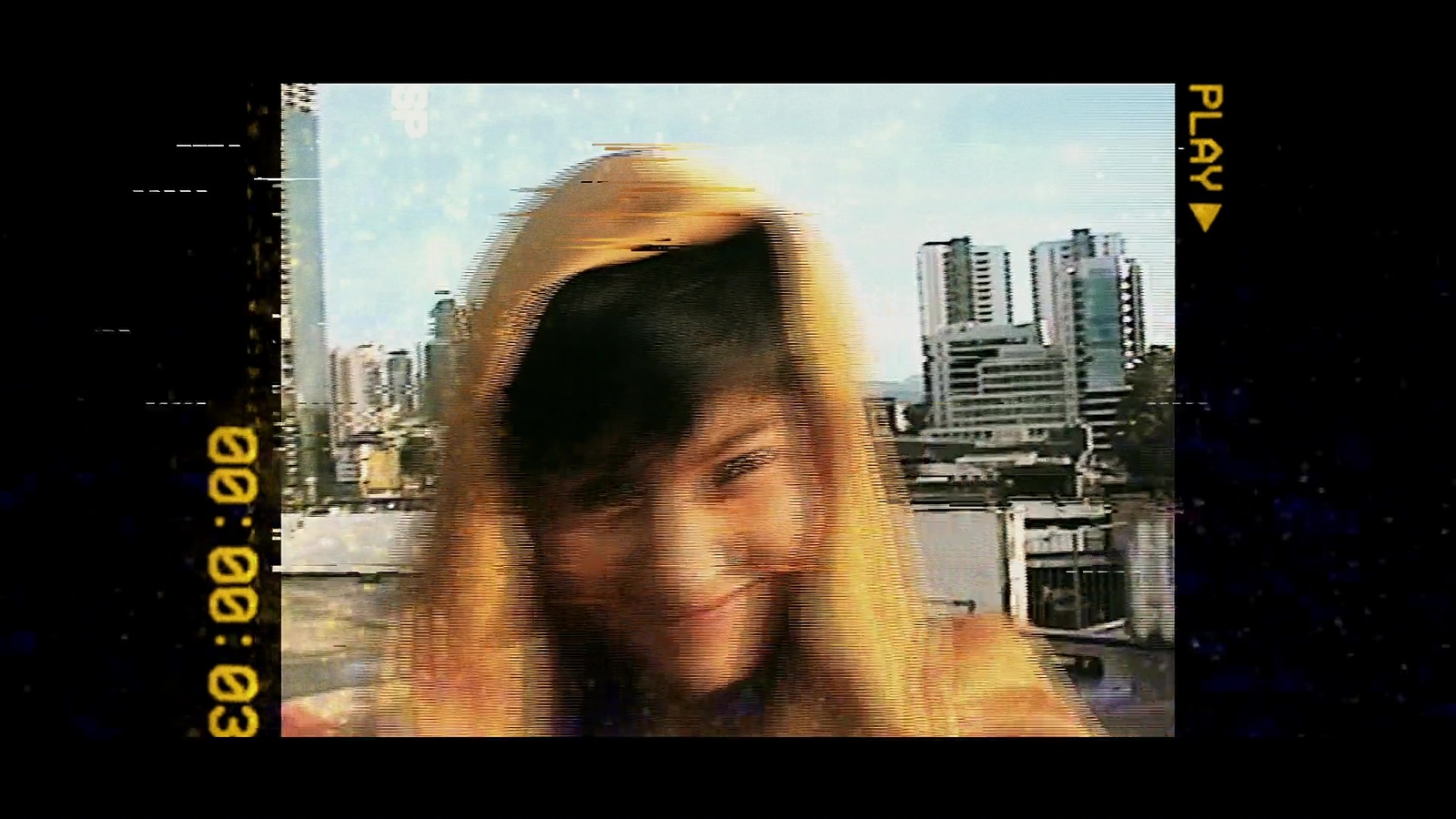 a woman with long blonde hair standing in front of a city skyline
