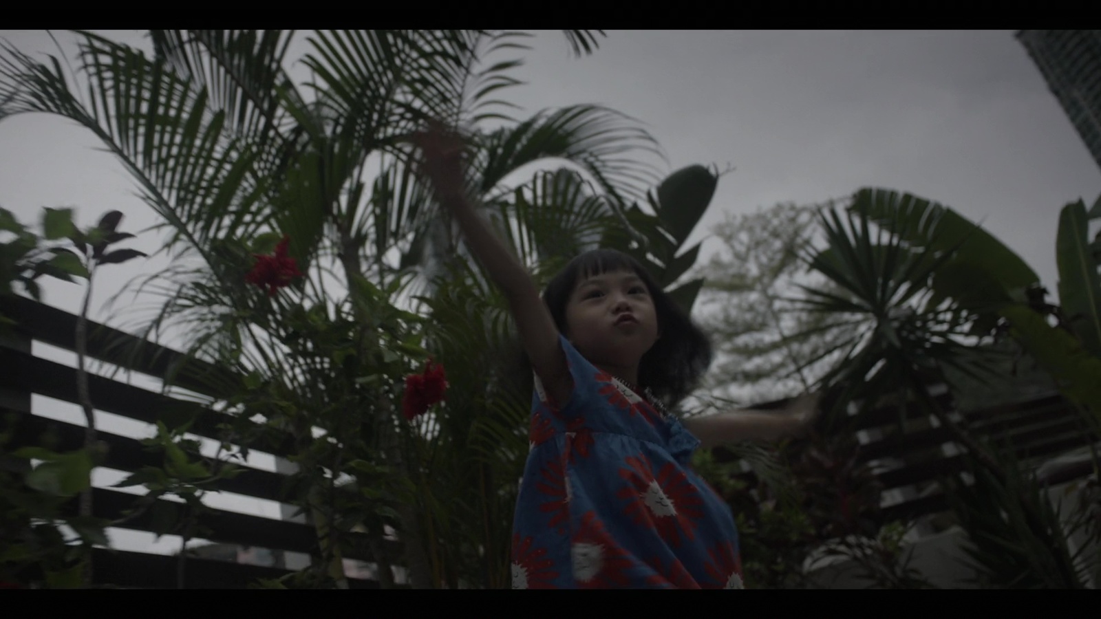 a young girl reaching up into the air