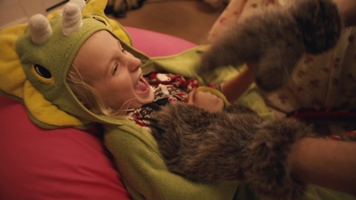 a little girl in a costume holding a cat