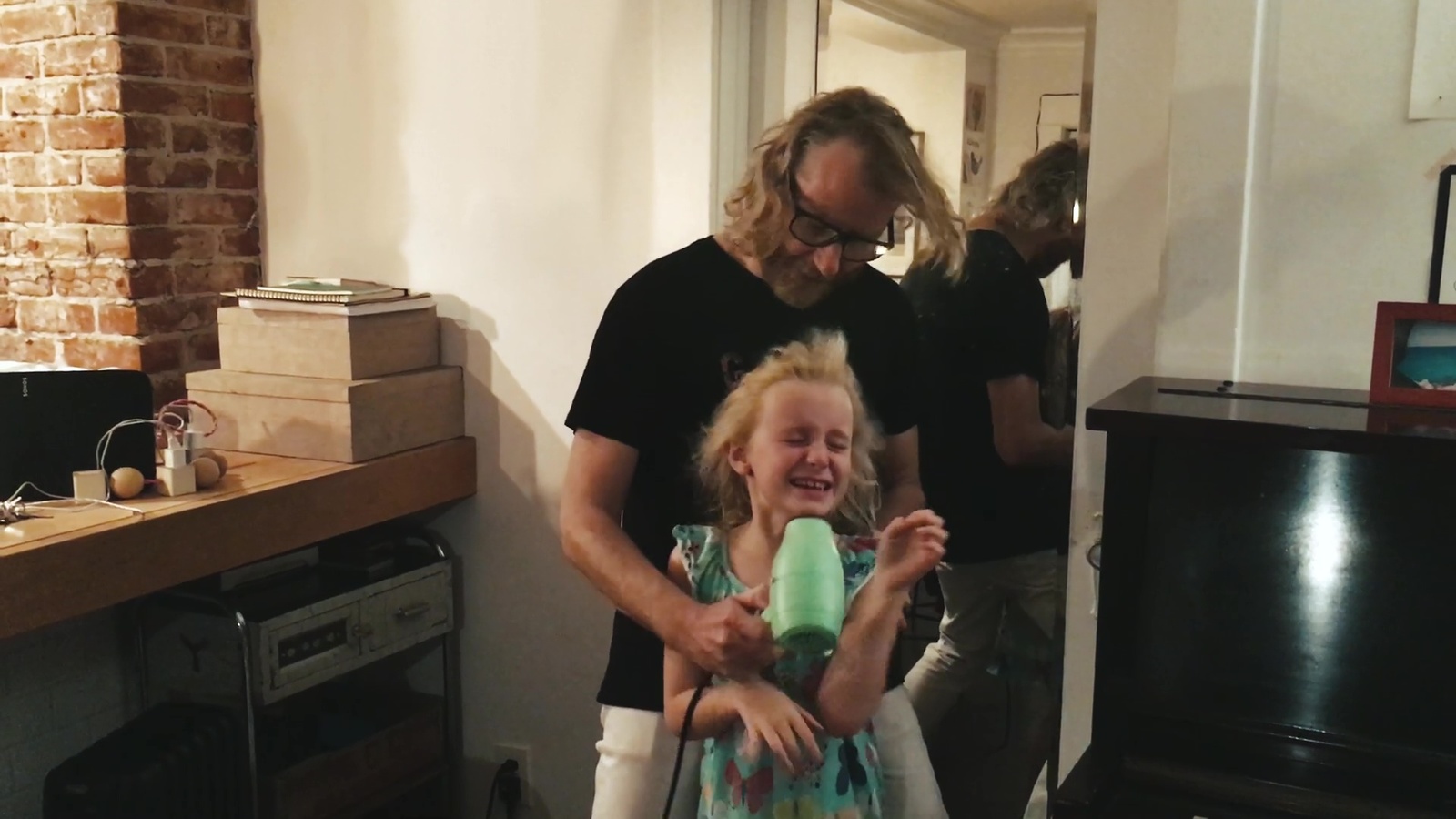 a man holding a little girl in a living room