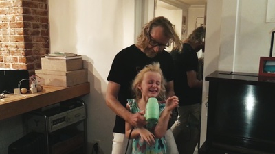 a man holding a little girl in a living room
