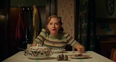 a woman sitting at a table with a plate of food