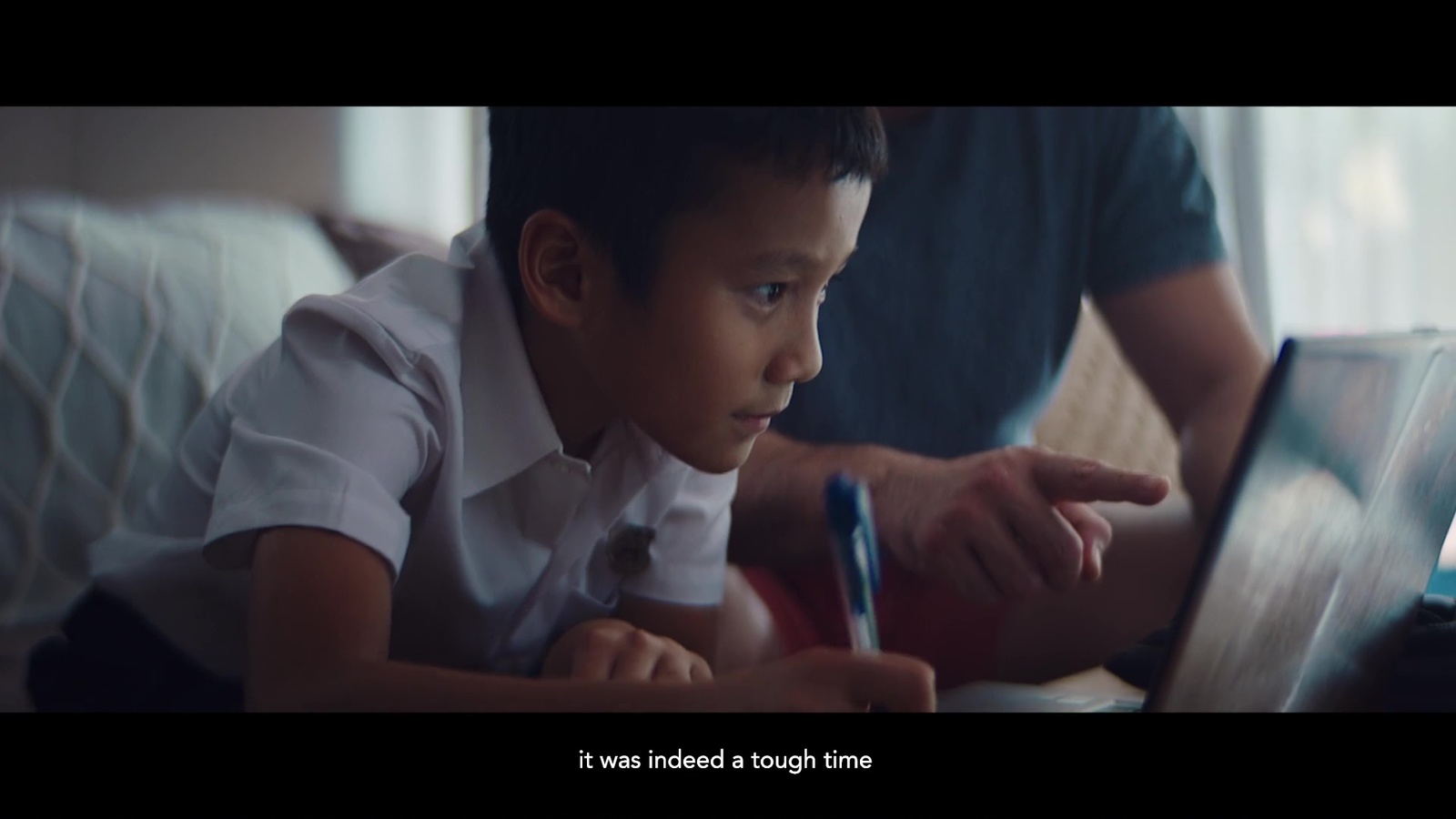 a young boy is looking at a laptop screen