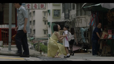 a group of people walking down a street next to tall buildings