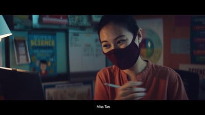 a woman wearing a face mask while looking at a laptop