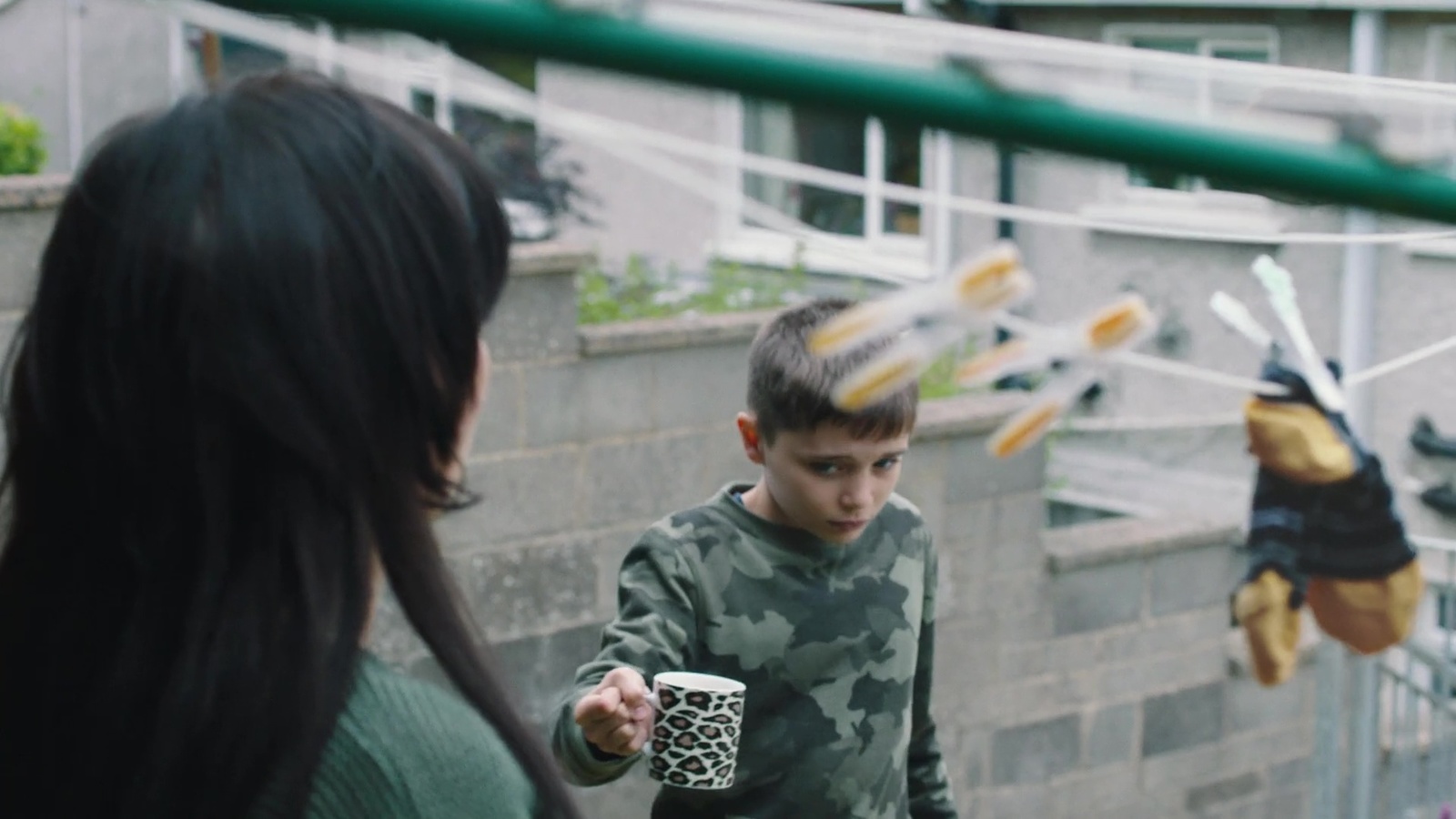 a young boy holding a coffee cup next to a woman