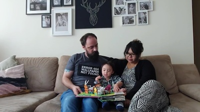 a man and woman sitting on a couch with a child