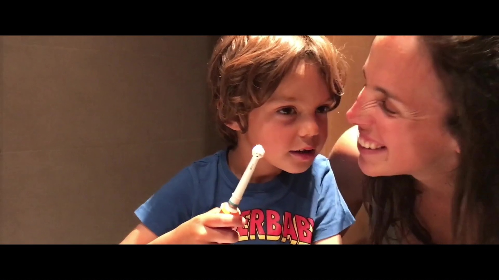 a woman and a child brushing their teeth