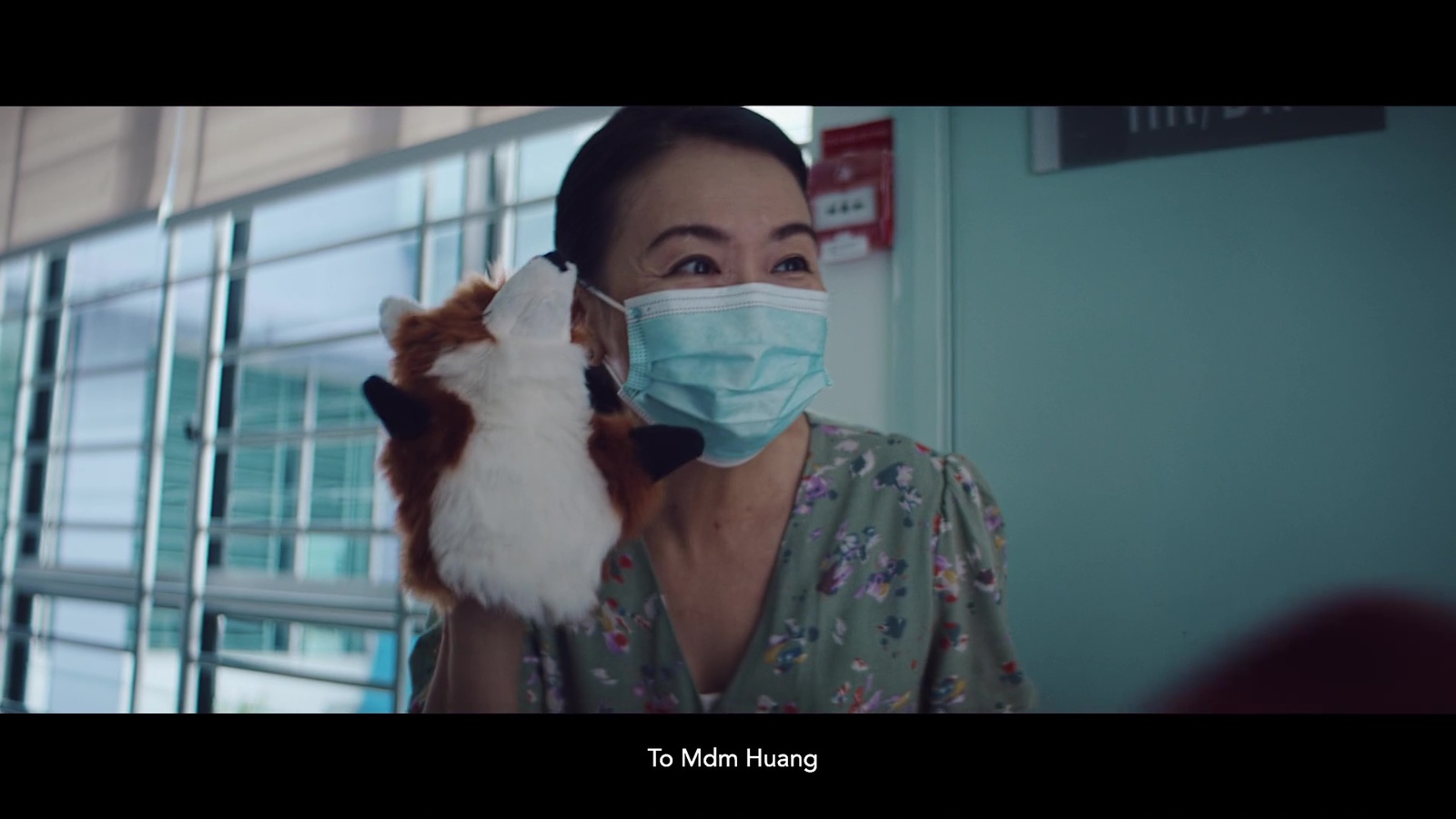 a woman wearing a face mask holding a cat