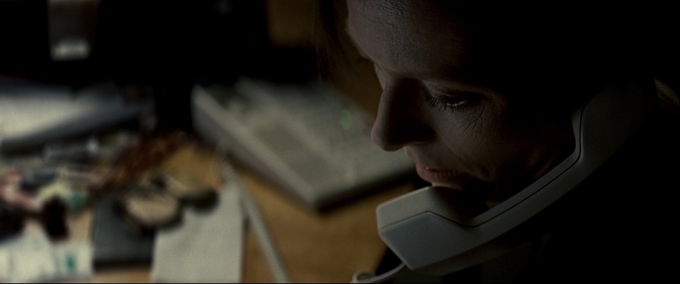 a woman talking on a phone in a dark room