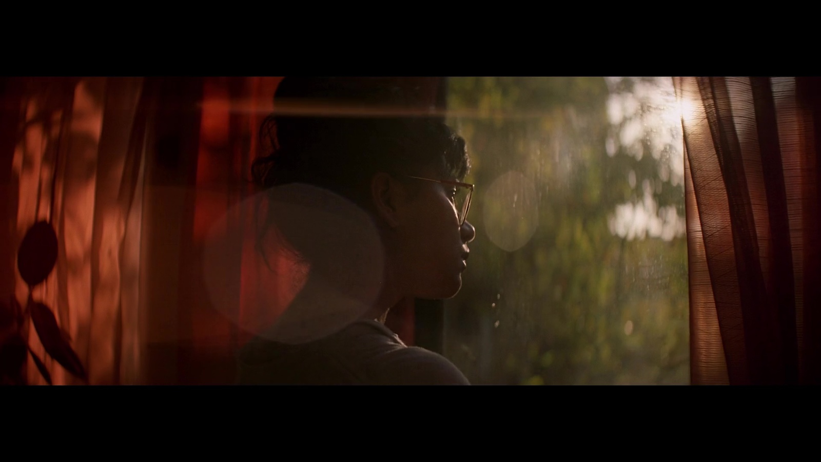 a woman looking out of a window at trees