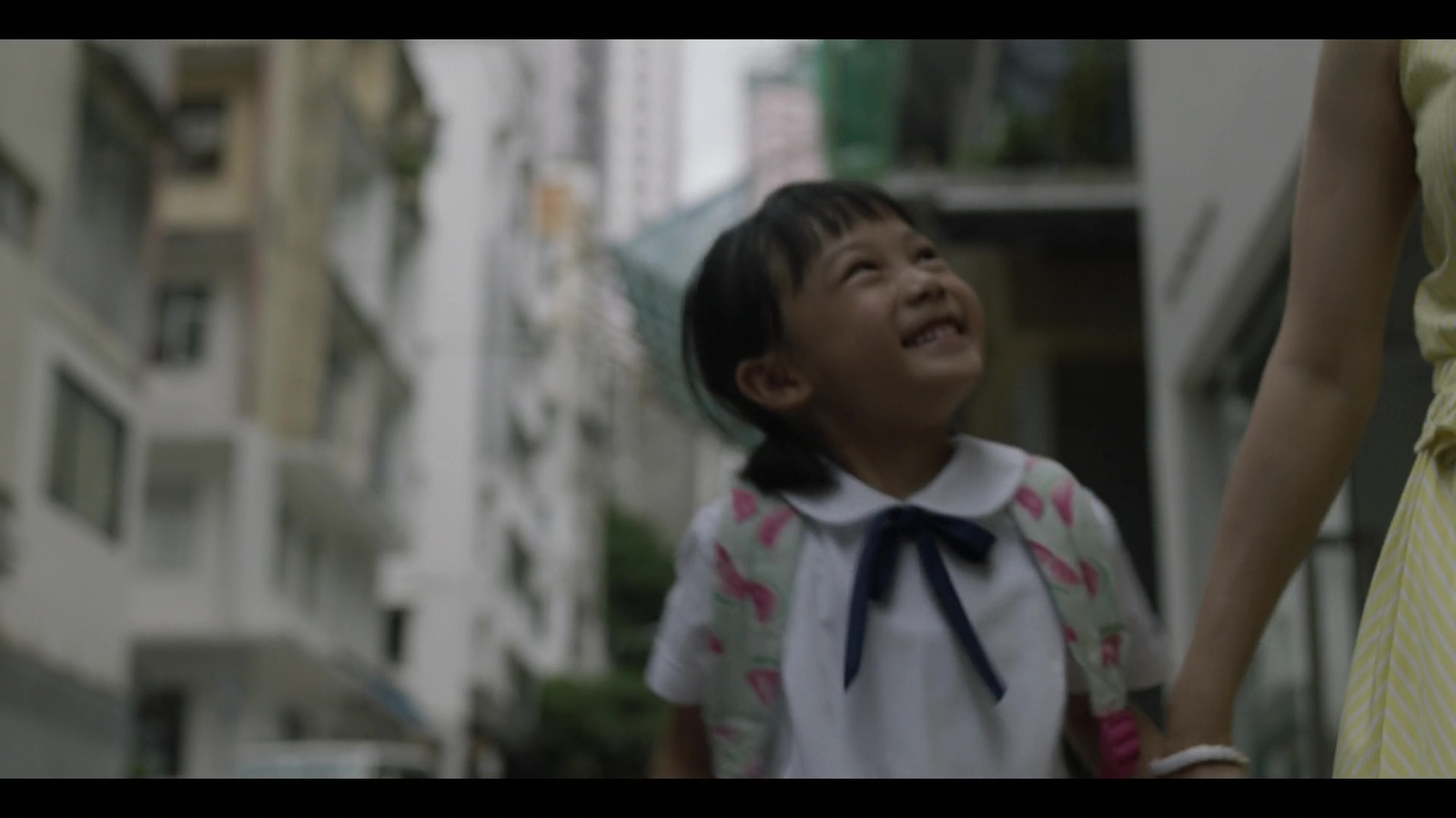 a little girl holding the hand of a woman