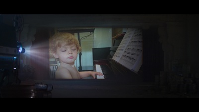 a young boy playing a piano in a dark room