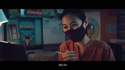 a woman wearing a face mask while looking at a laptop