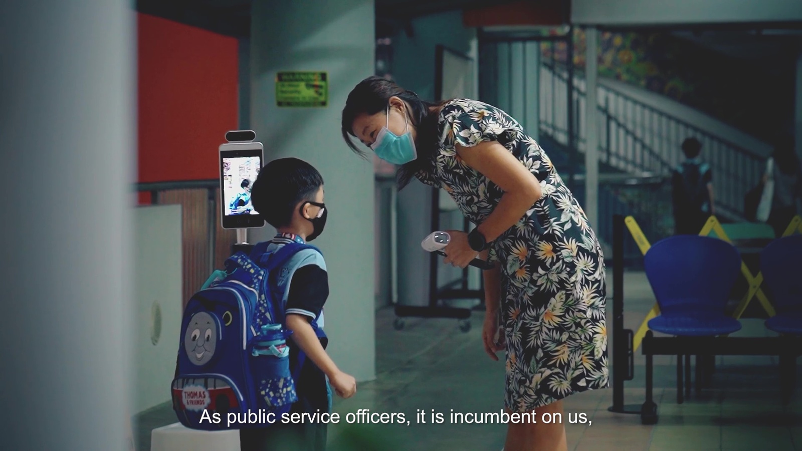 a woman wearing a face mask standing next to a child