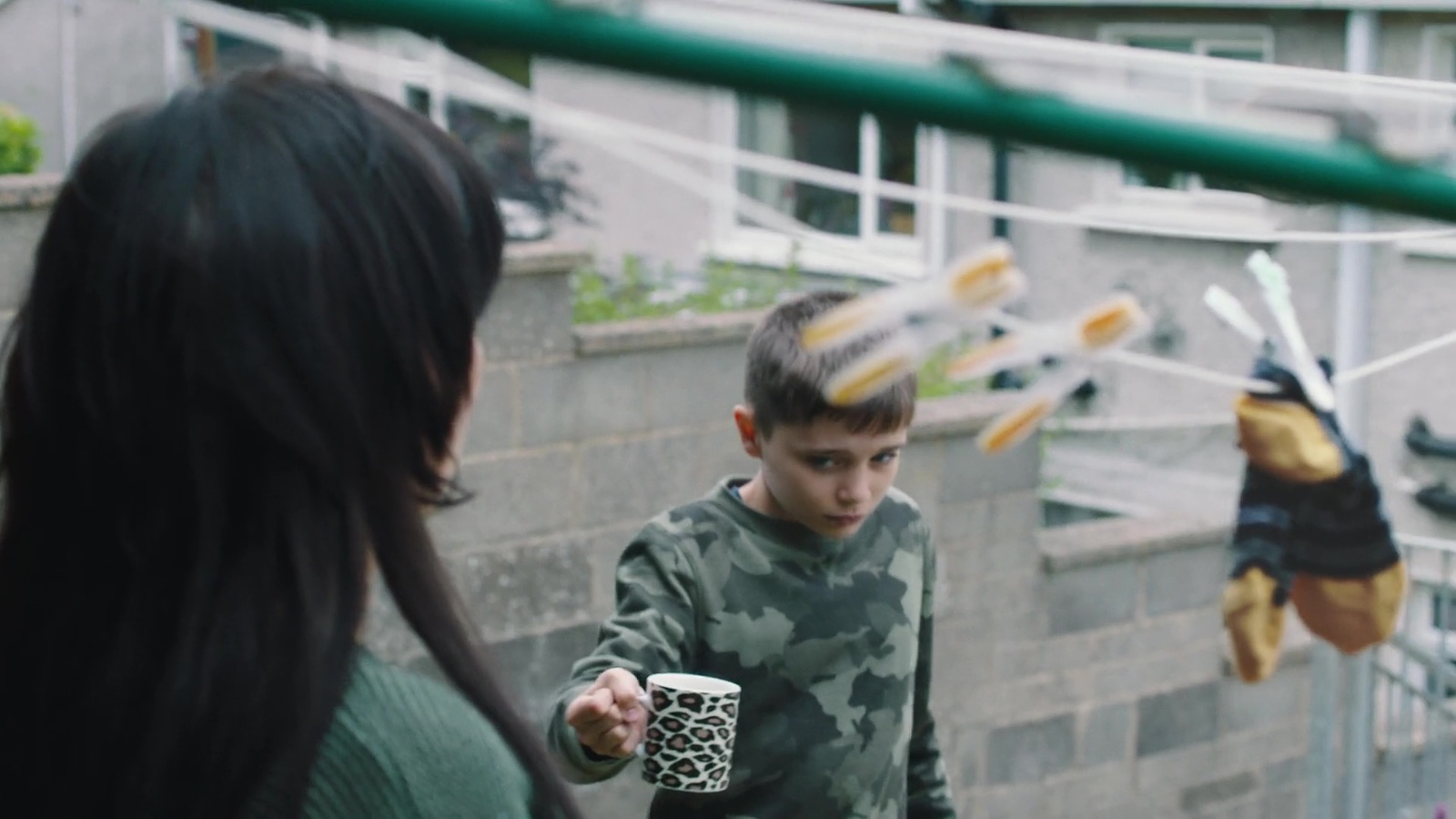 a woman holding a cup next to a little boy