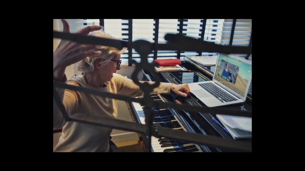 a woman is playing a keyboard in front of a laptop