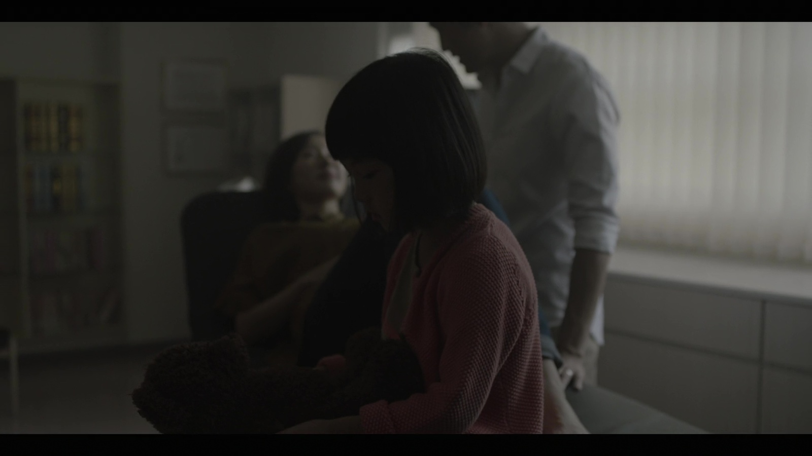 a woman holding a teddy bear in a living room