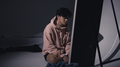 a man sitting on the floor in front of a mirror