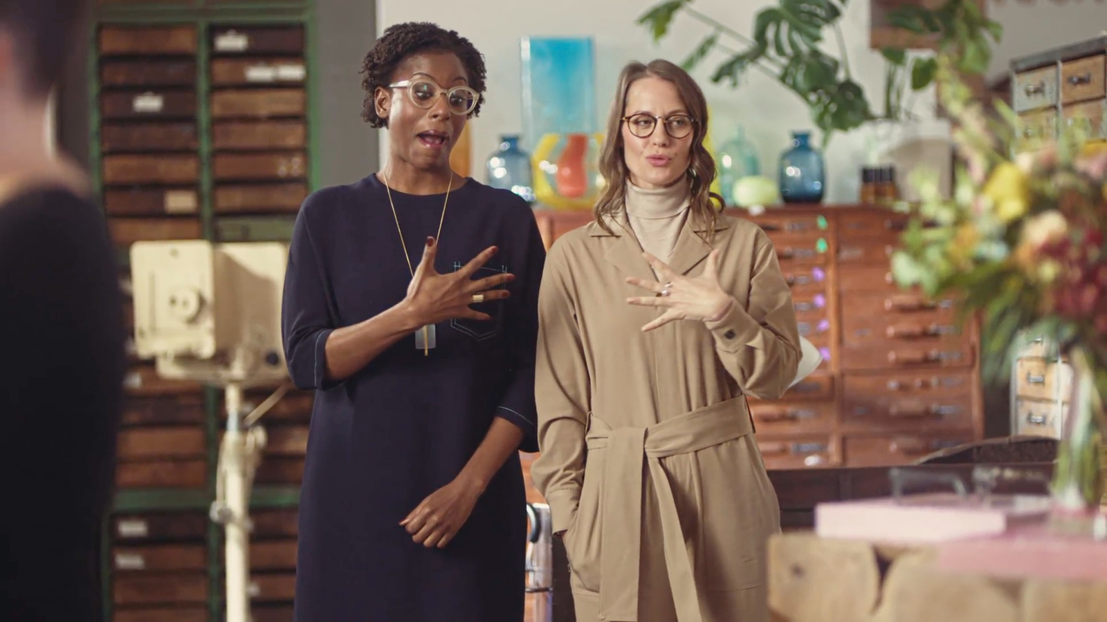 two women standing next to each other in a room