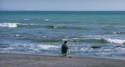 a man in a wheel chair on the beach