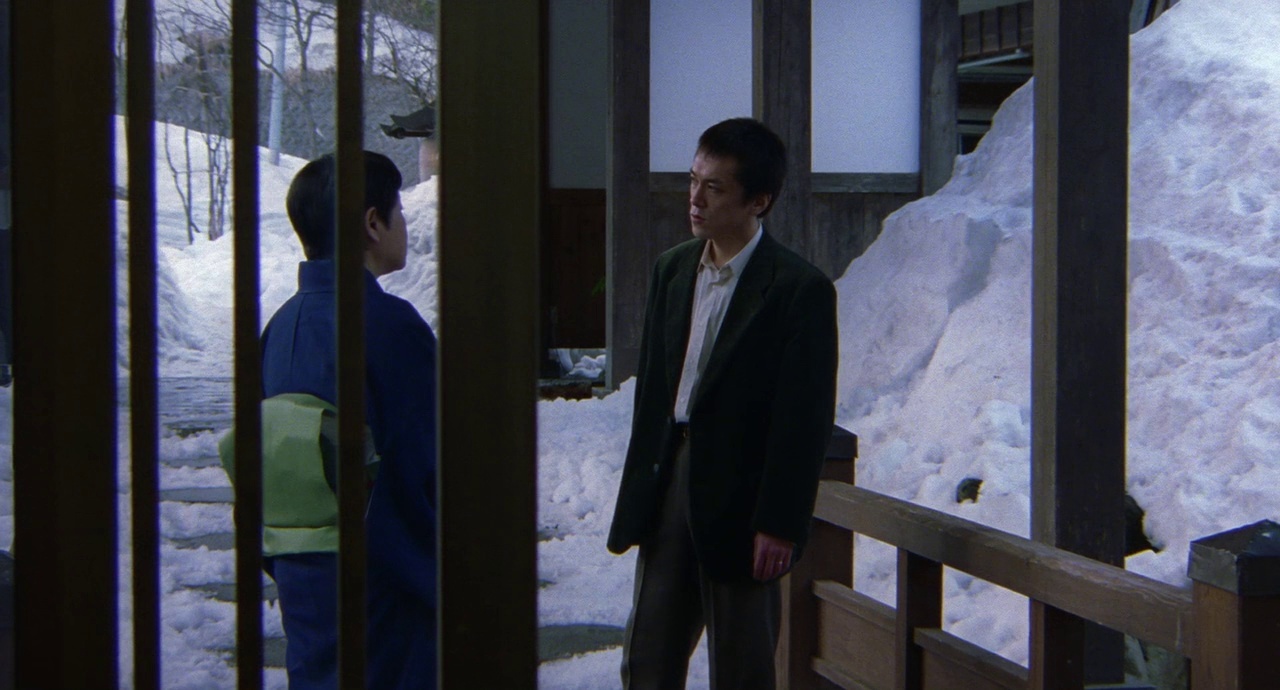 a man standing in front of a snow covered mountain