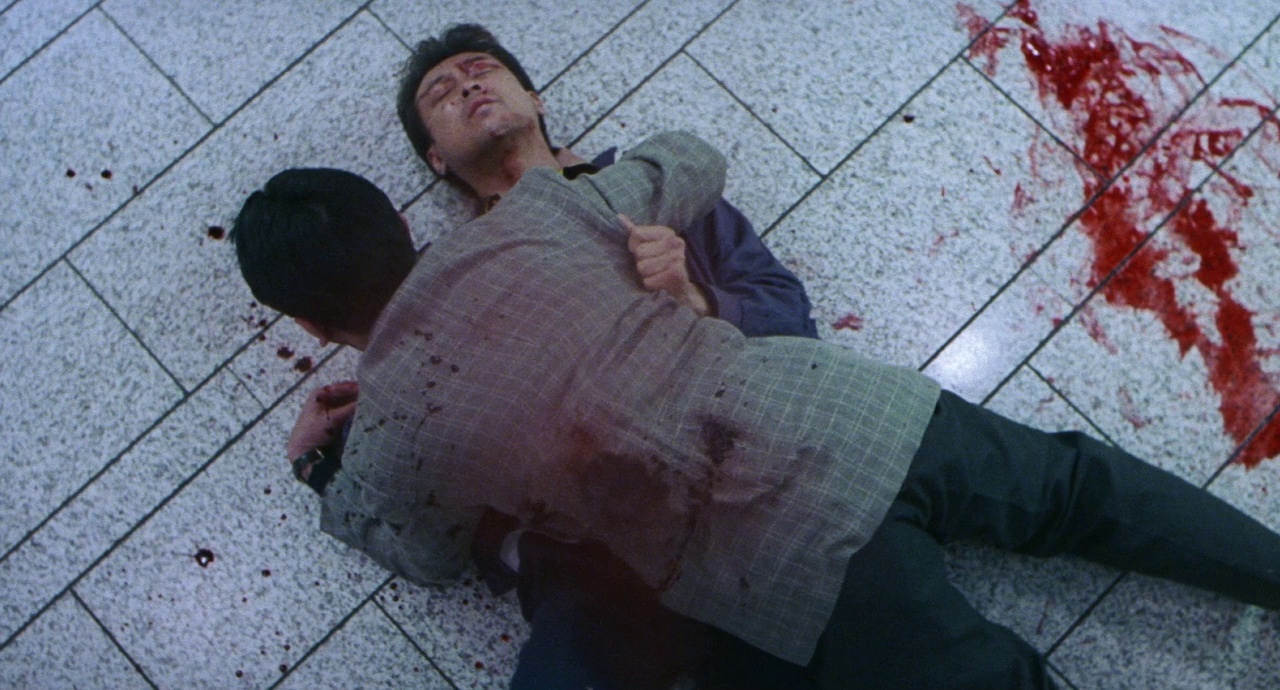 a man laying on the ground with a knife in his hand