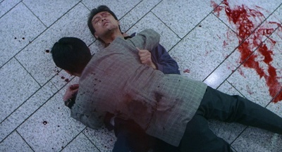 a man laying on the ground with a knife in his hand