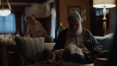 a man sitting on top of a couch next to a little girl