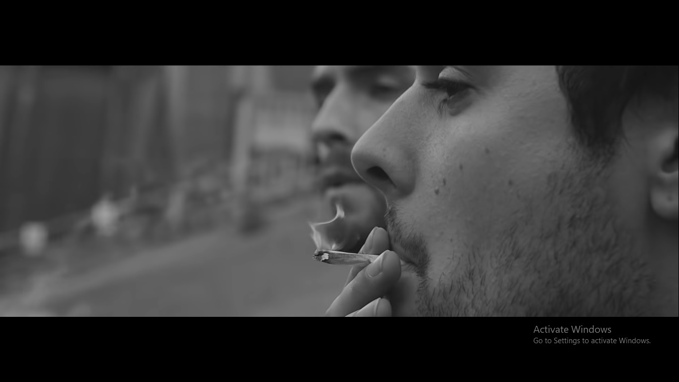 a man smoking a cigarette in a black and white photo