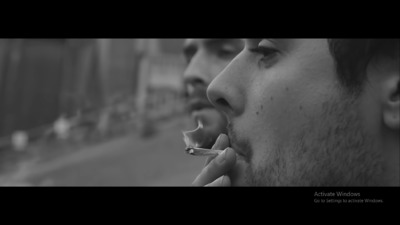 a man smoking a cigarette in a black and white photo