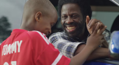 a man and a young boy standing in the back of a car