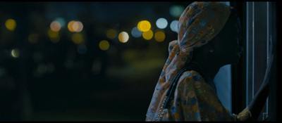 a woman is looking out of a window at night