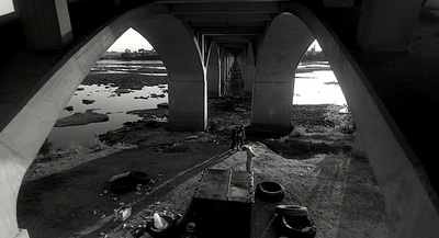 a black and white photo of a bridge over water