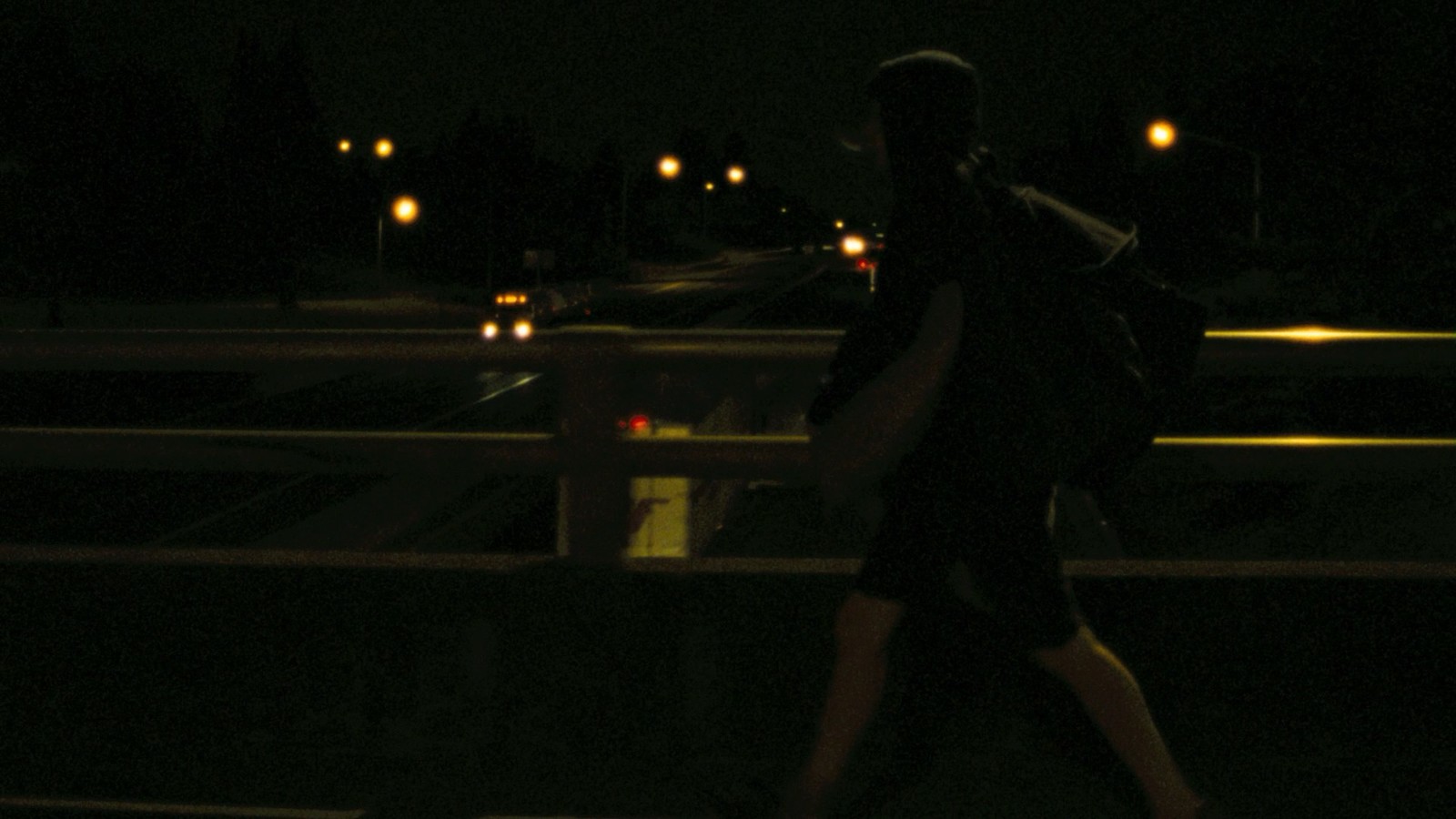 a person walking across a bridge at night