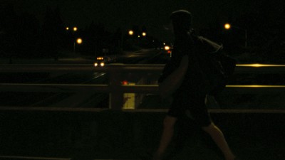 a person walking across a bridge at night