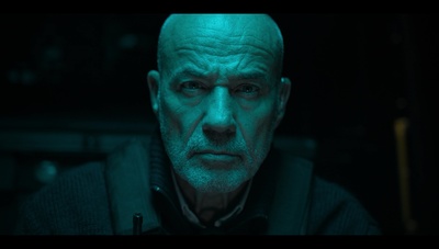 a man in a dark room with a green light on his face