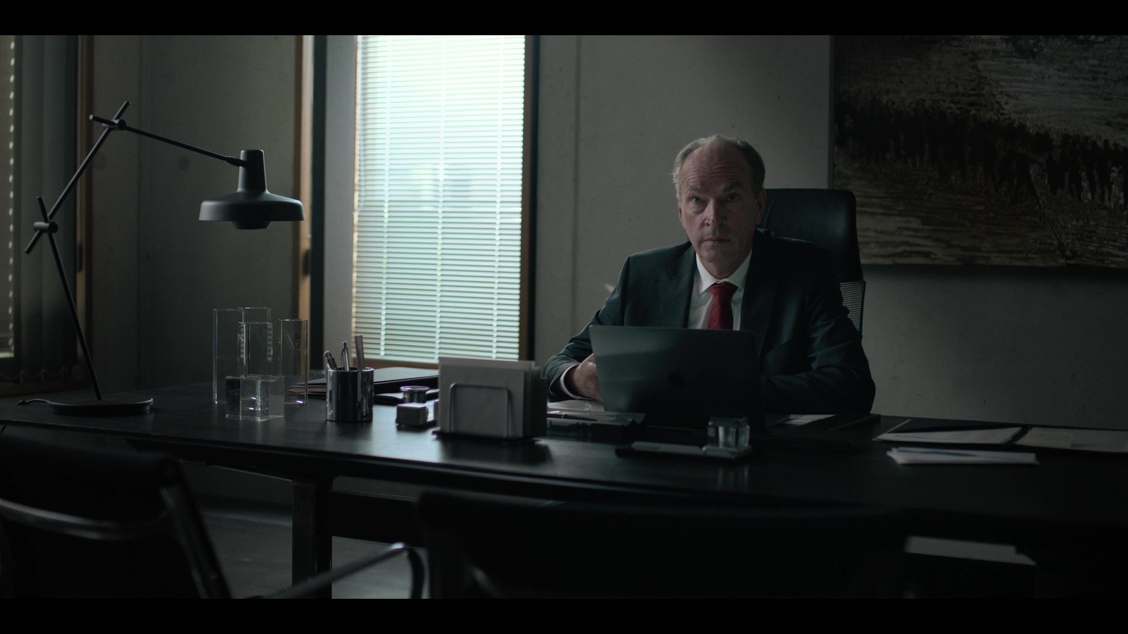 a man in a suit sitting at a desk