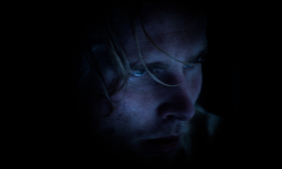 a man in a dark room staring at something