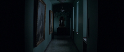 a dark hallway with a painting hanging on the wall