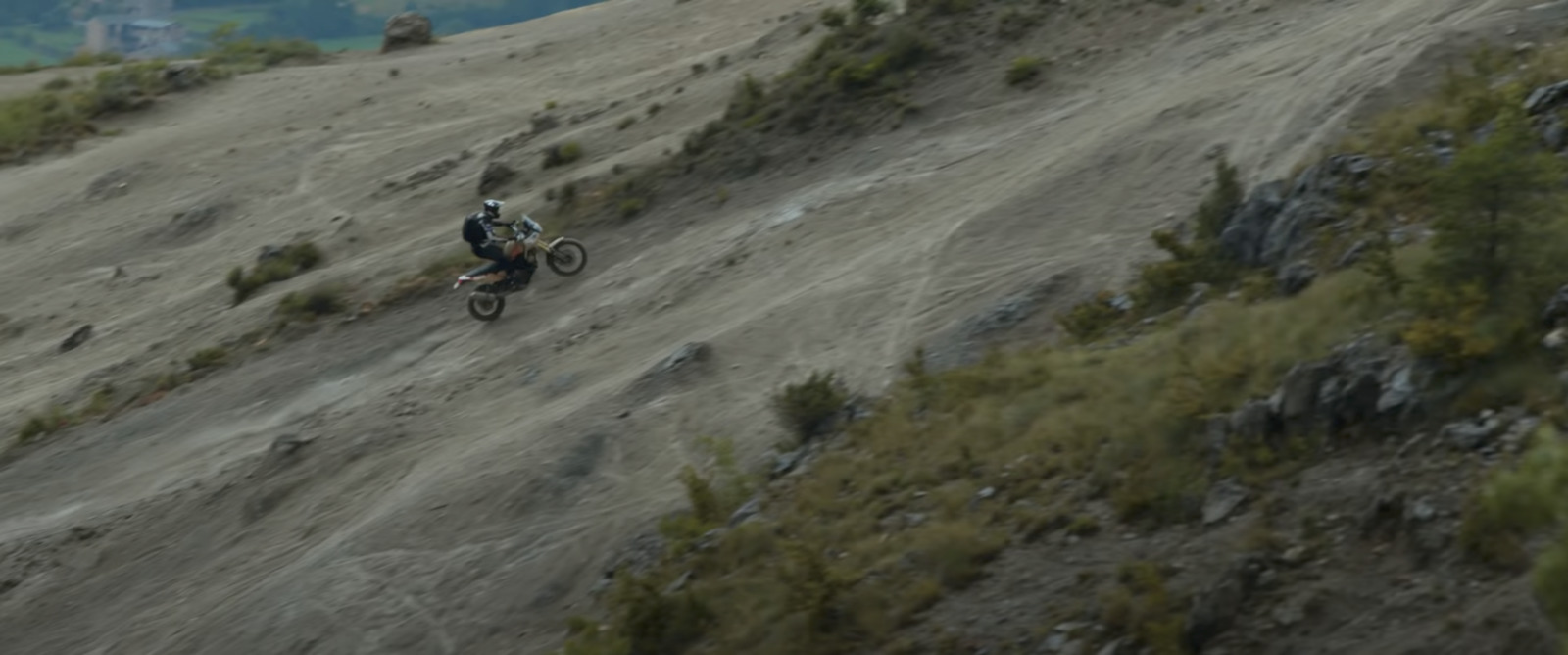 a man riding a dirt bike down a hill