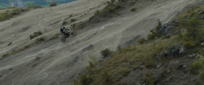 a man riding a dirt bike down a hill