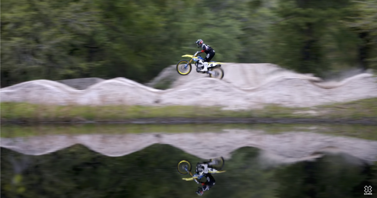 a man riding a dirt bike on top of a lake