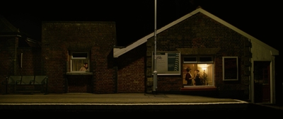 a person standing in a doorway of a brick building at night