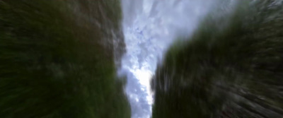 a blurry photo of a road going through a forest