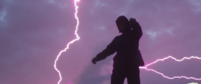 a man standing in front of a purple sky with lightning