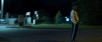 a man standing on the side of a road at night