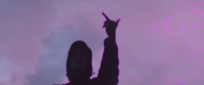 a silhouette of a person holding a cell phone up in the air