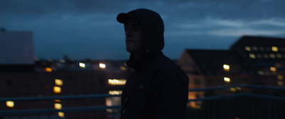 a man standing on a balcony at night