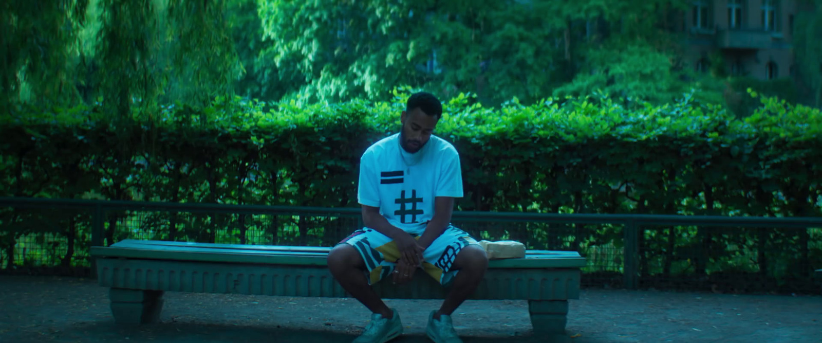 a man sitting on a bench in a park